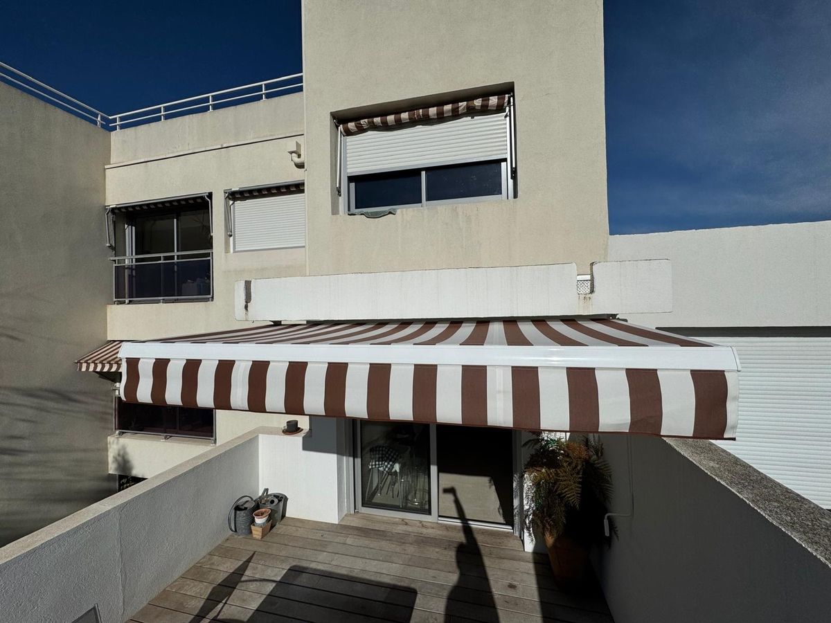 Store banne rayé marron-blanc sur terrasse, volets roulants