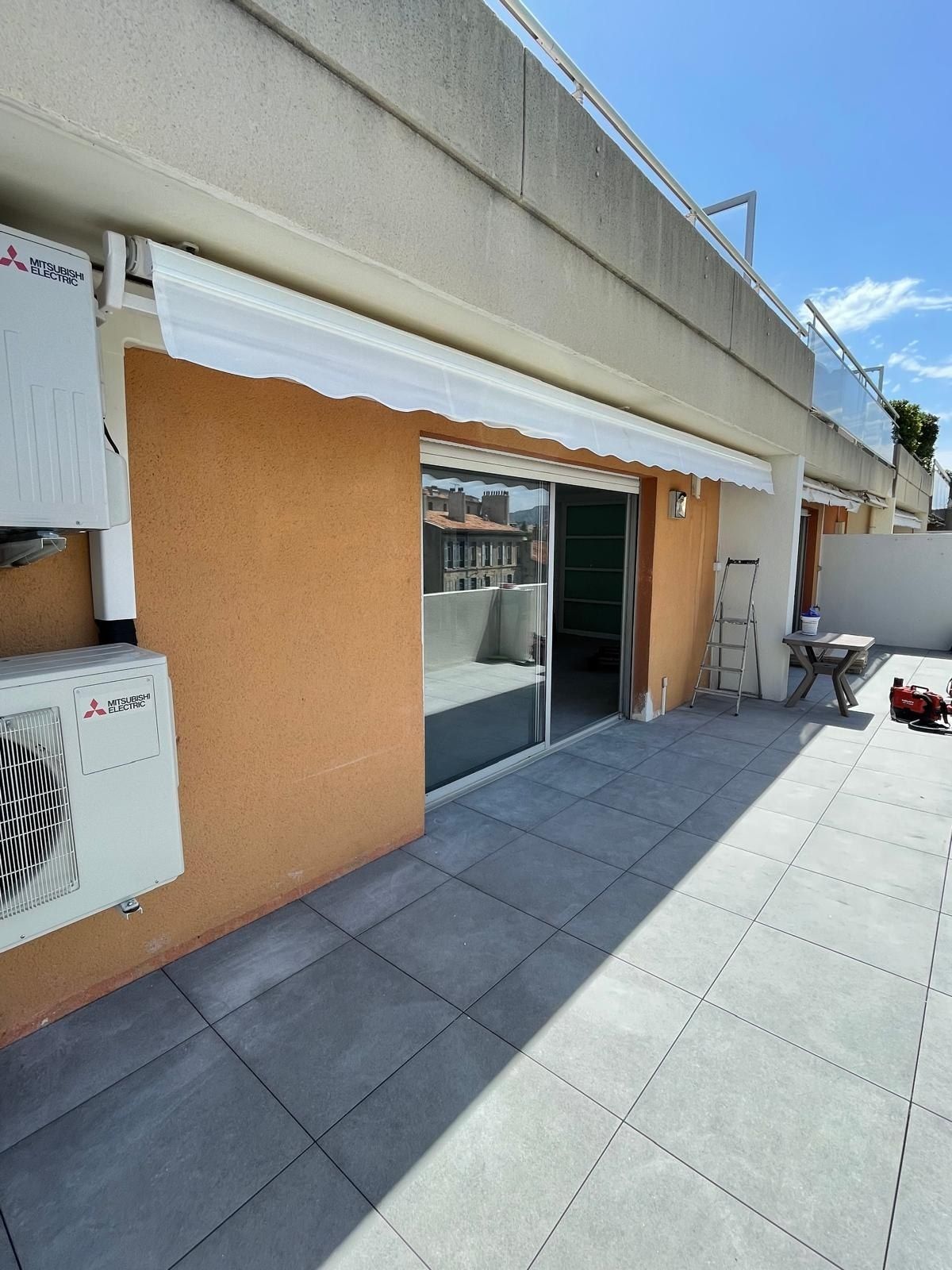 Store banne blanc sur terrasse en hauteur avec vue sur Marseille